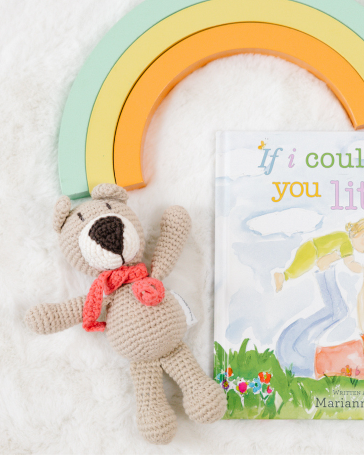 דובי סרוג לבן מתוק על רקע ספר ילדים וקשת בענן - סיפור לפני השינה